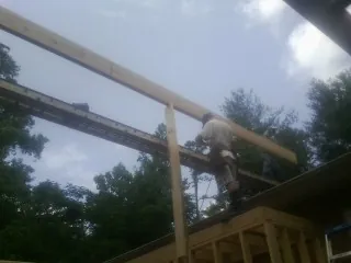 Carpenter setting a ridge beam over a new addition frame — Ice Dam Removal by Roofing Brothers in Oregonia