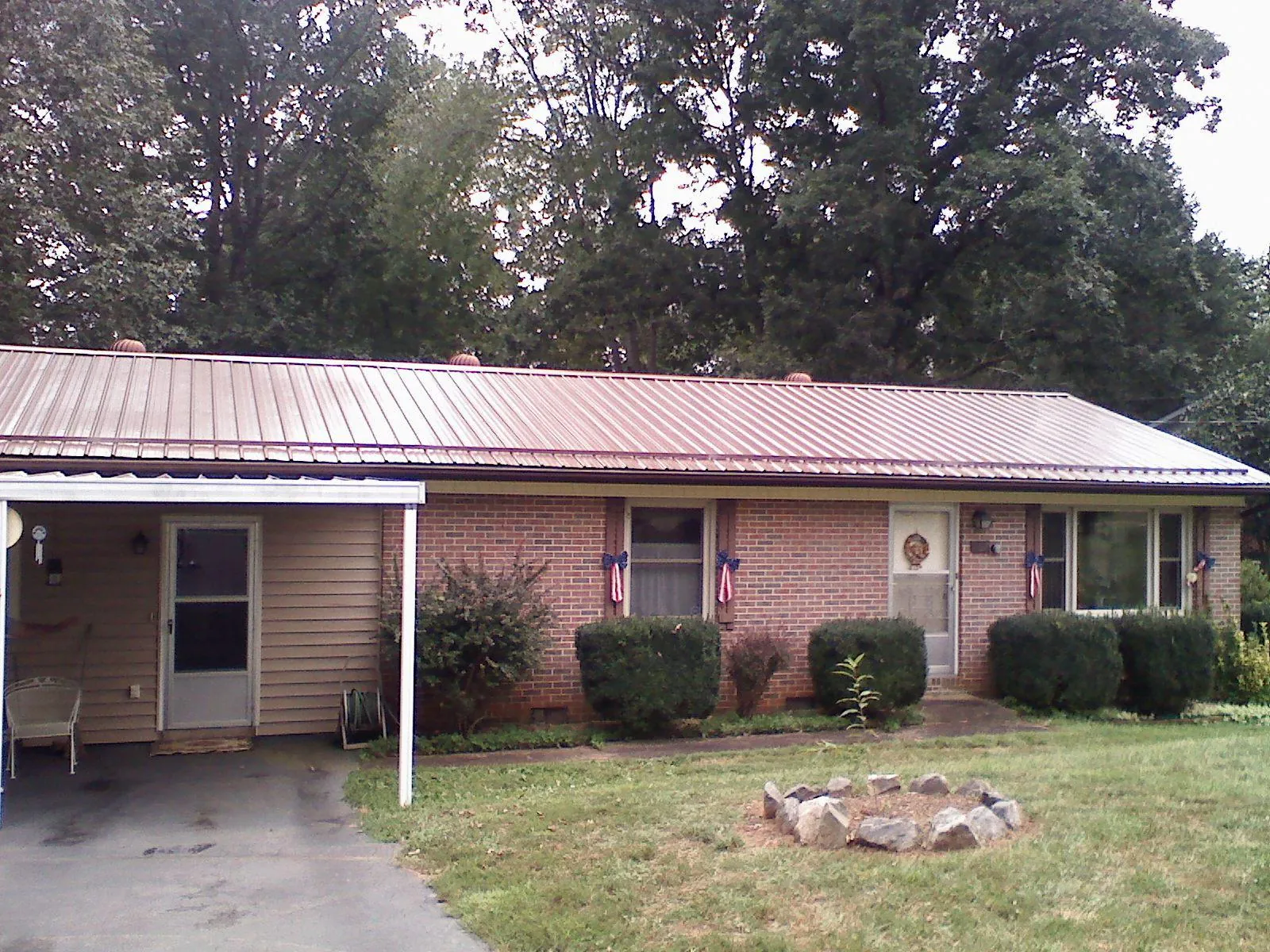 Bronze metal roof and carport on a brick ranch home — Roof Repair work by our crew in Oregonia
