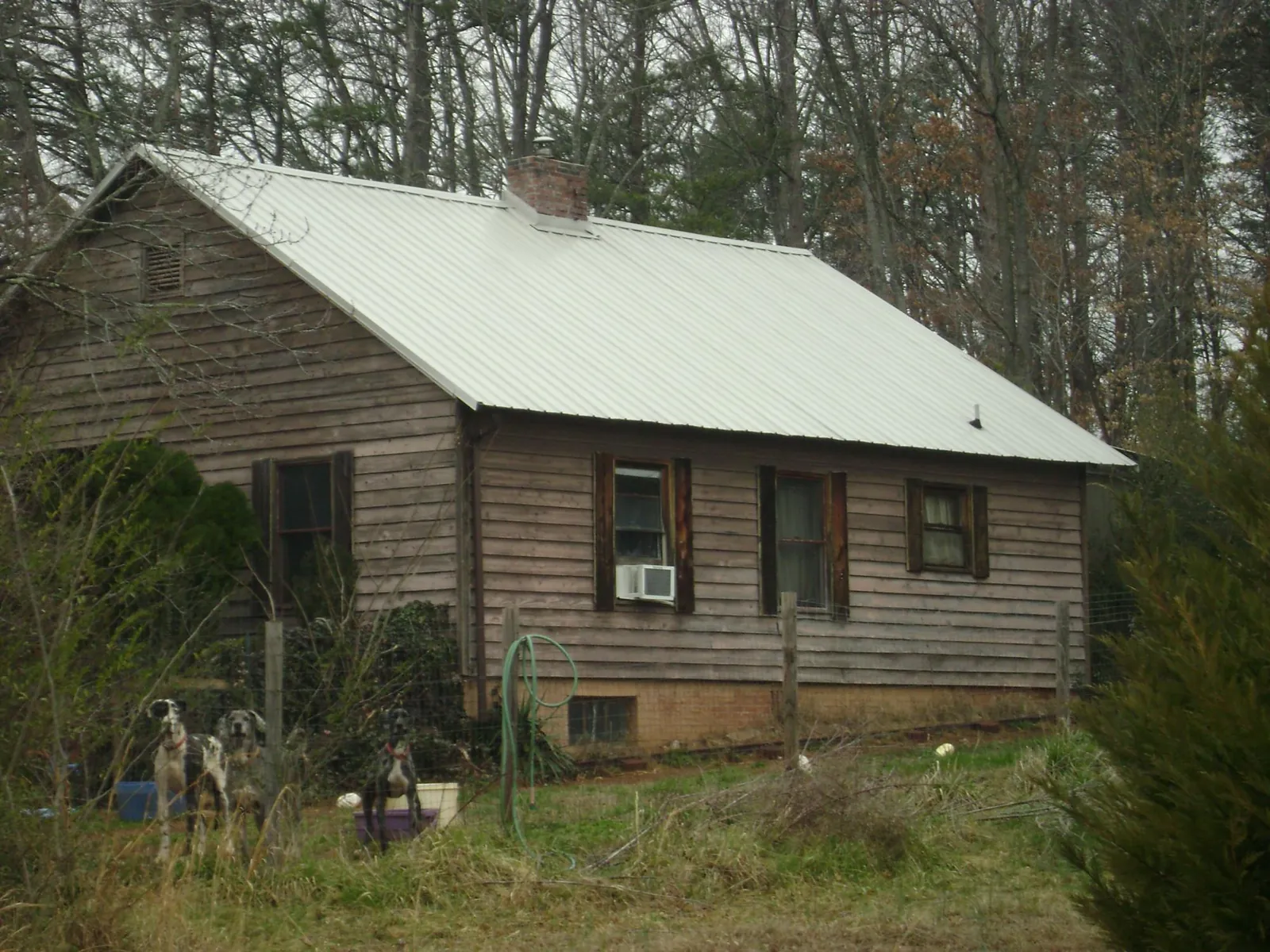 White metal roof on an old wood sided farmhouse, from a Metal Roof Installation job in Oregonia